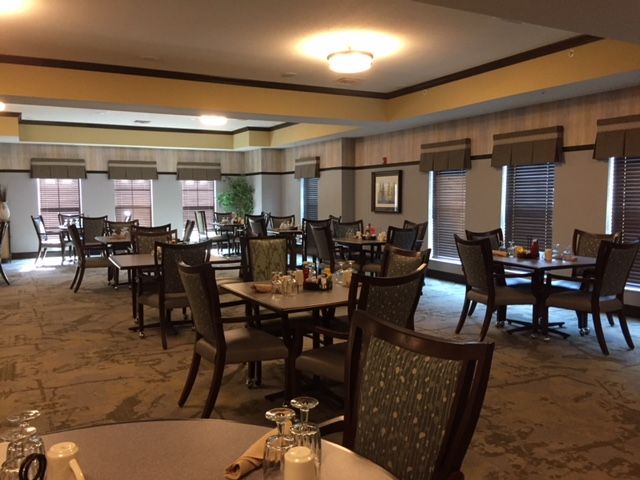 An empty dining room with neatly arranged tables and chairs.
