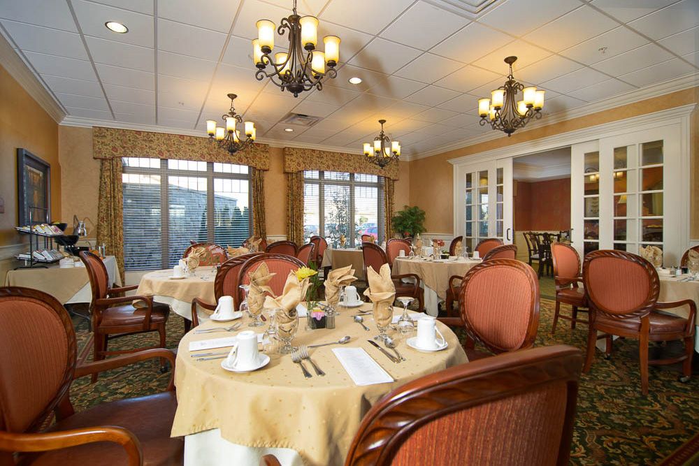 Elegant dining room with neatly set tables and warm lighting.