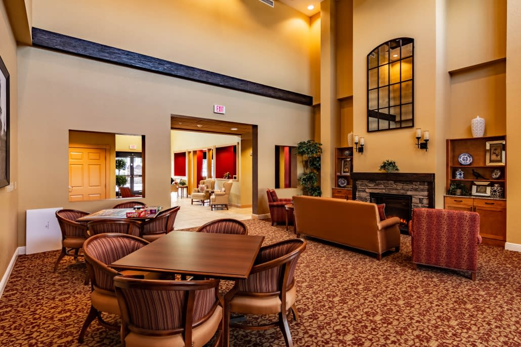 A hotel lobby with comfortable seating, a fireplace, and high ceilings.