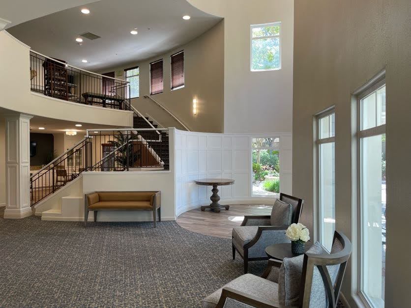 A modern lobby with elegant seating, ample lighting, and a staircase.