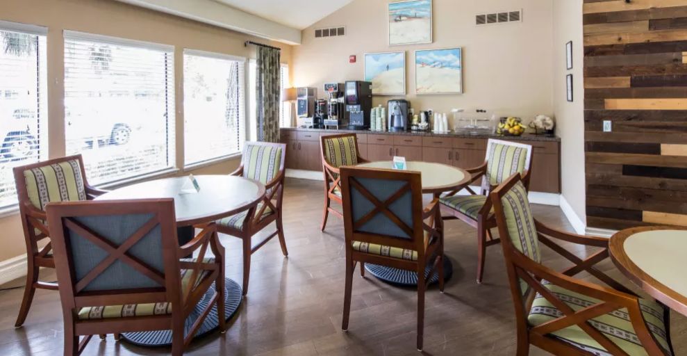 A cozy cafe seating area with tables, chairs, and a coffee station.