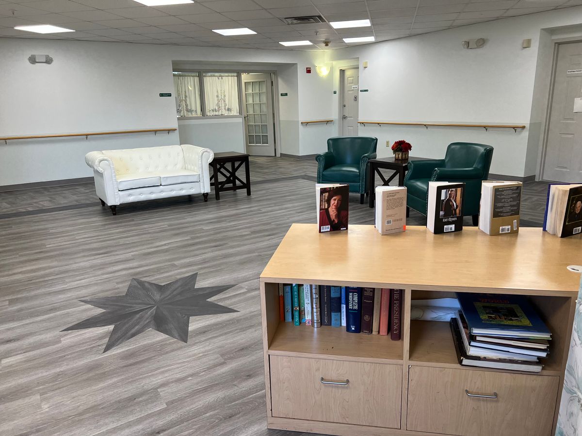 A modern lobby with comfortable seating and a selection of books.