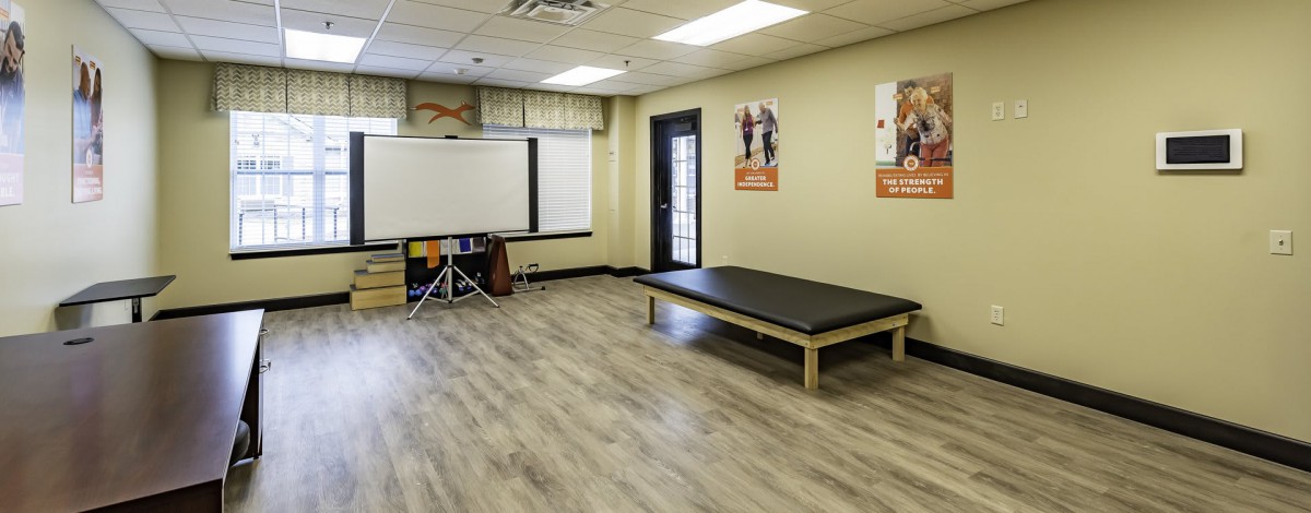 An empty rehabilitation room with an exercise mat and motivational posters on the walls.