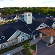 Aerial view of a residential building with a prominent entrance and landscaped surroundings.
