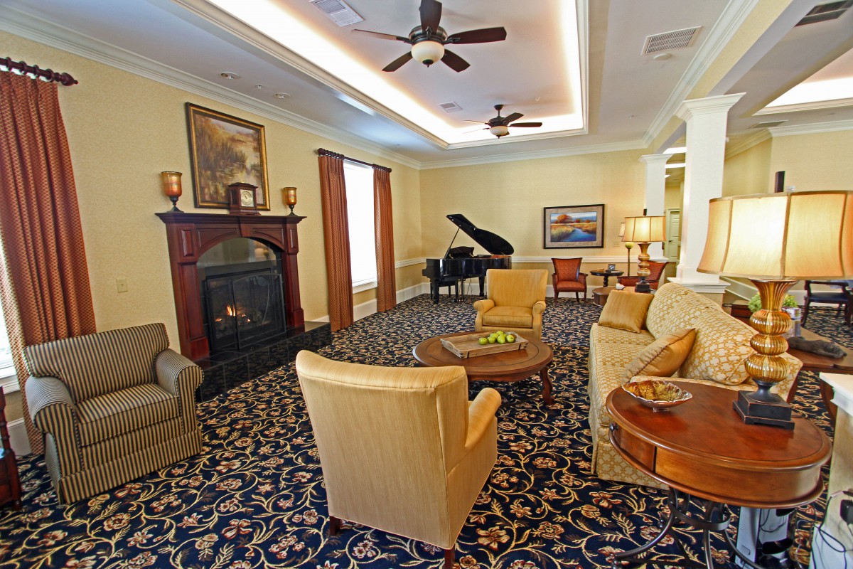 A well-furnished living room featuring a grand piano and a cozy fireplace.
