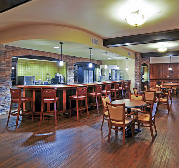 A cozy bar and restaurant interior with wooden seating and brick walls.