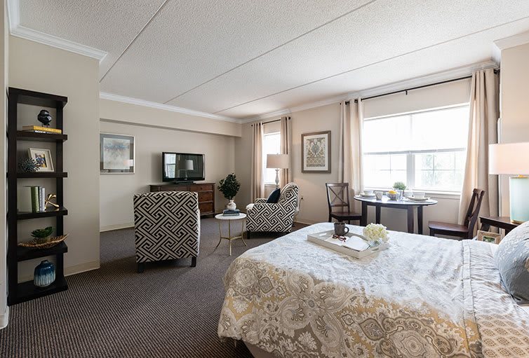 Spacious bedroom with seating area and modern decor.