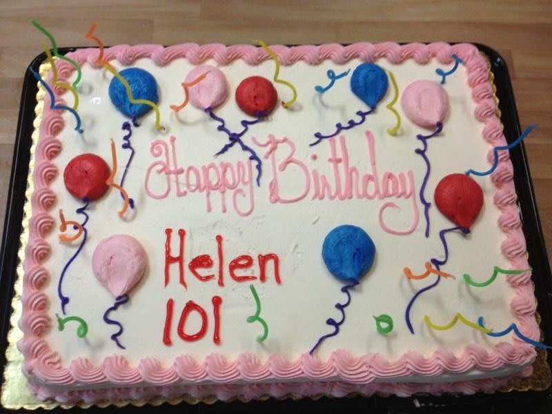 A festive birthday cake adorned with colorful balloon decorations and icing, celebrating Helen's 101st birthday.