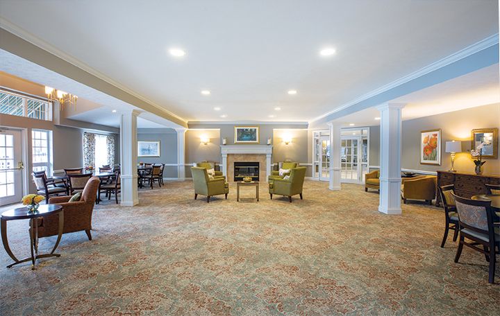 A spacious living room with comfortable seating and a central fireplace.