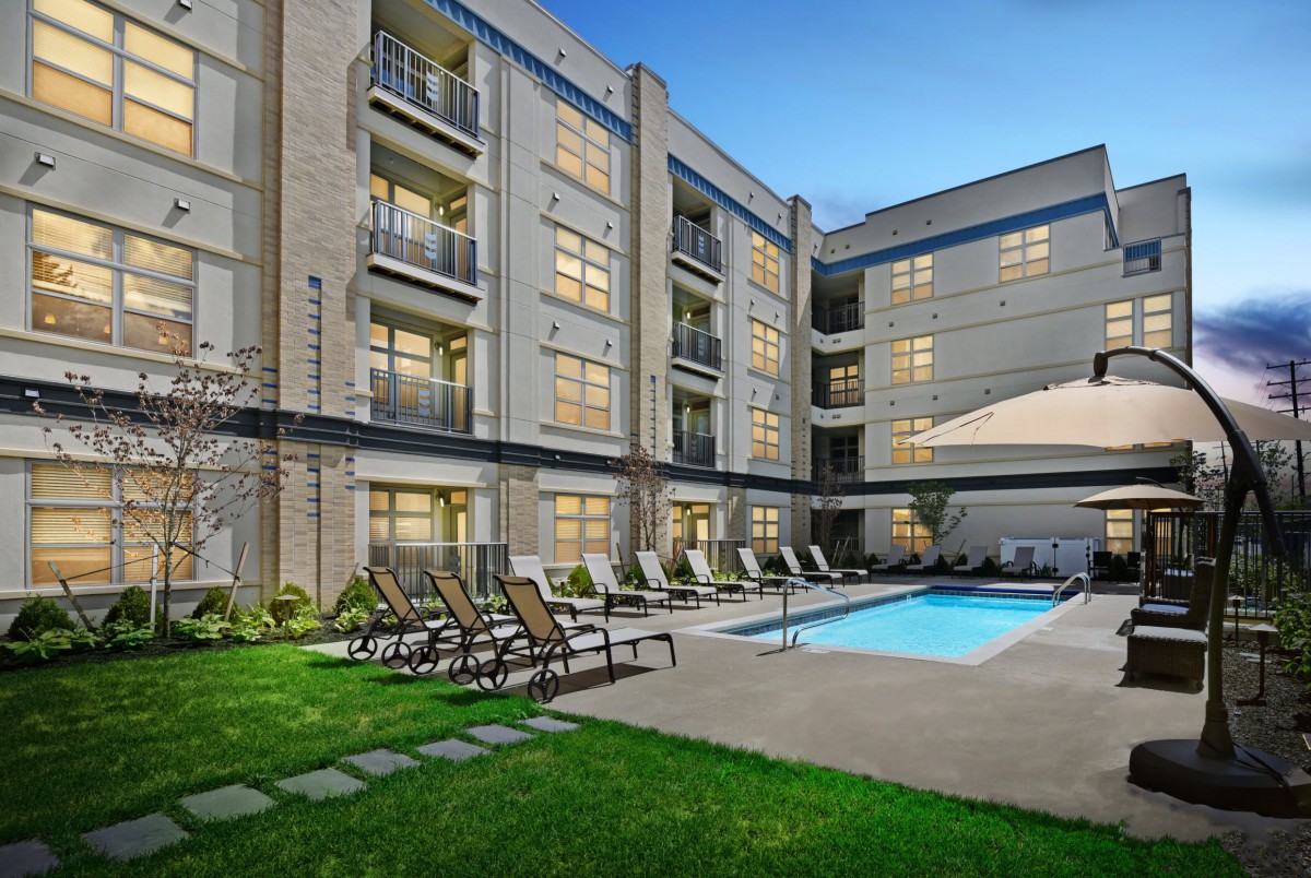 Modern residential complex with a swimming pool and outdoor lounge area.