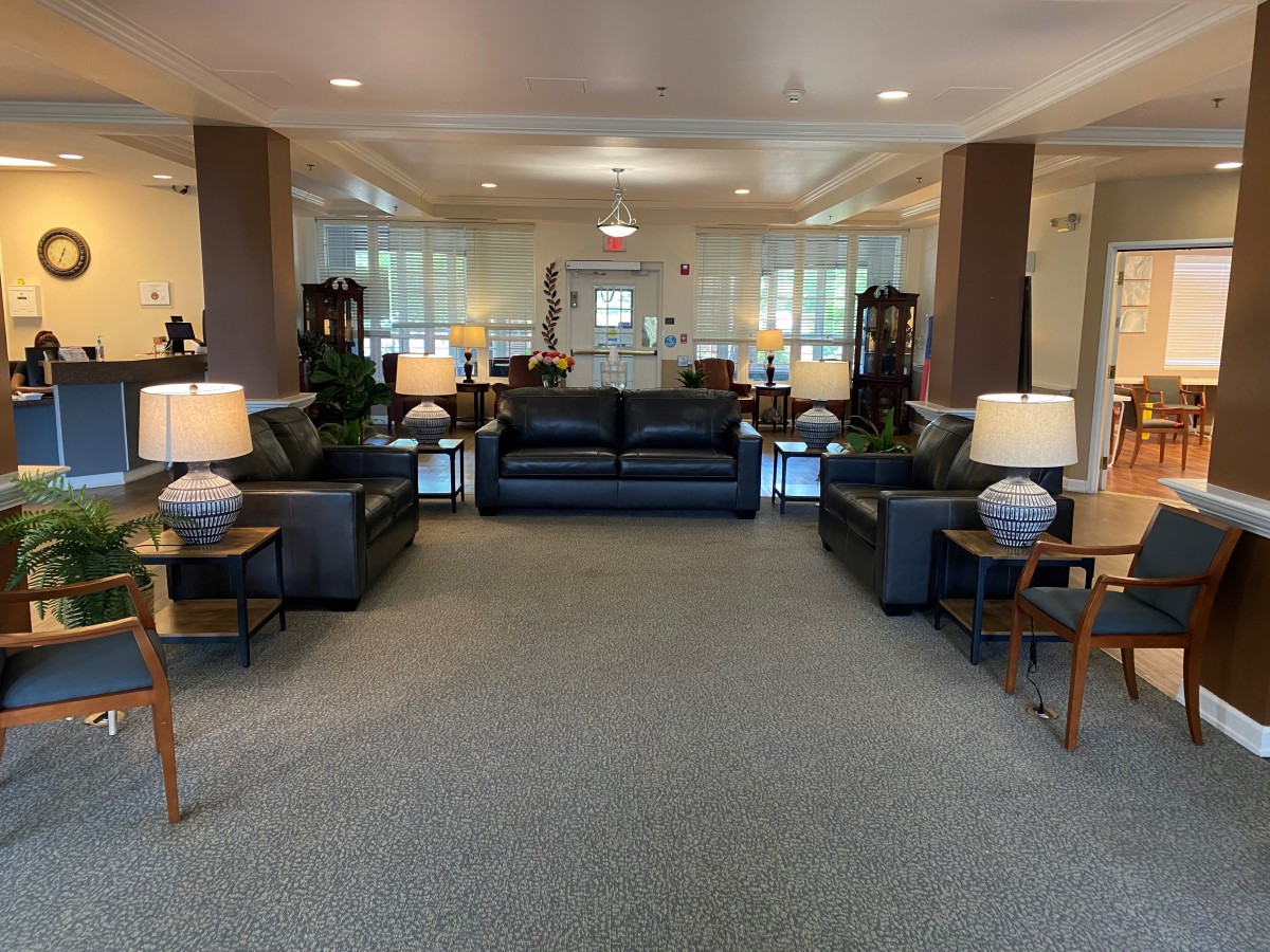 A spacious lobby area with sofas, tables, and lamps arranged symmetrically.