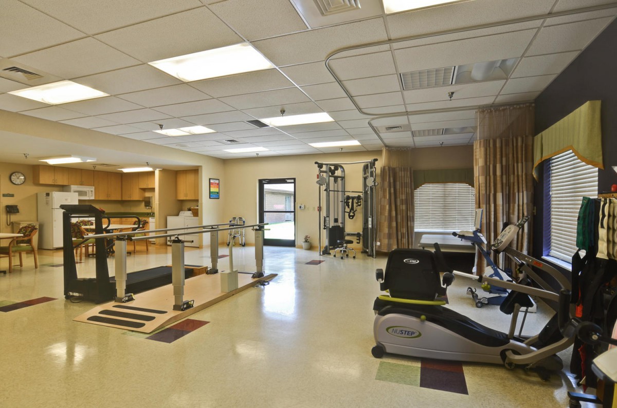 A rehabilitation gym equipped with exercise machines and therapy stations.
