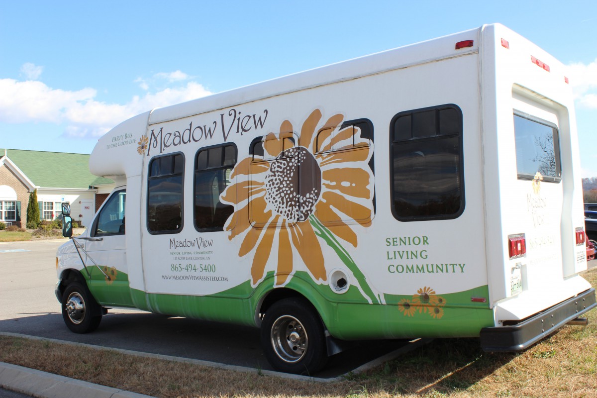 A community transport vehicle with a sunflower design on the side.