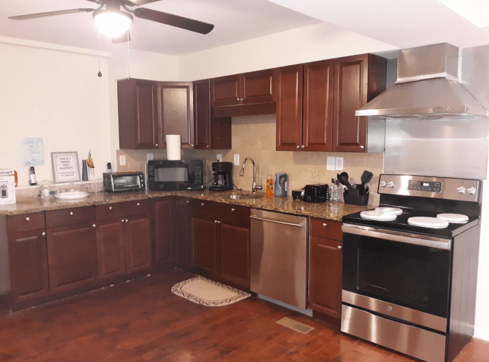 A modern kitchen with dark wood cabinets and stainless steel appliances.