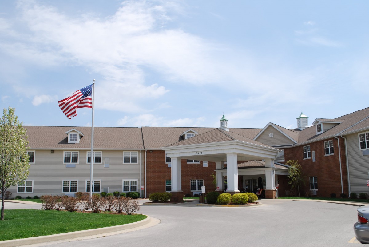 An entrance to a building with an American flag and a driveway.