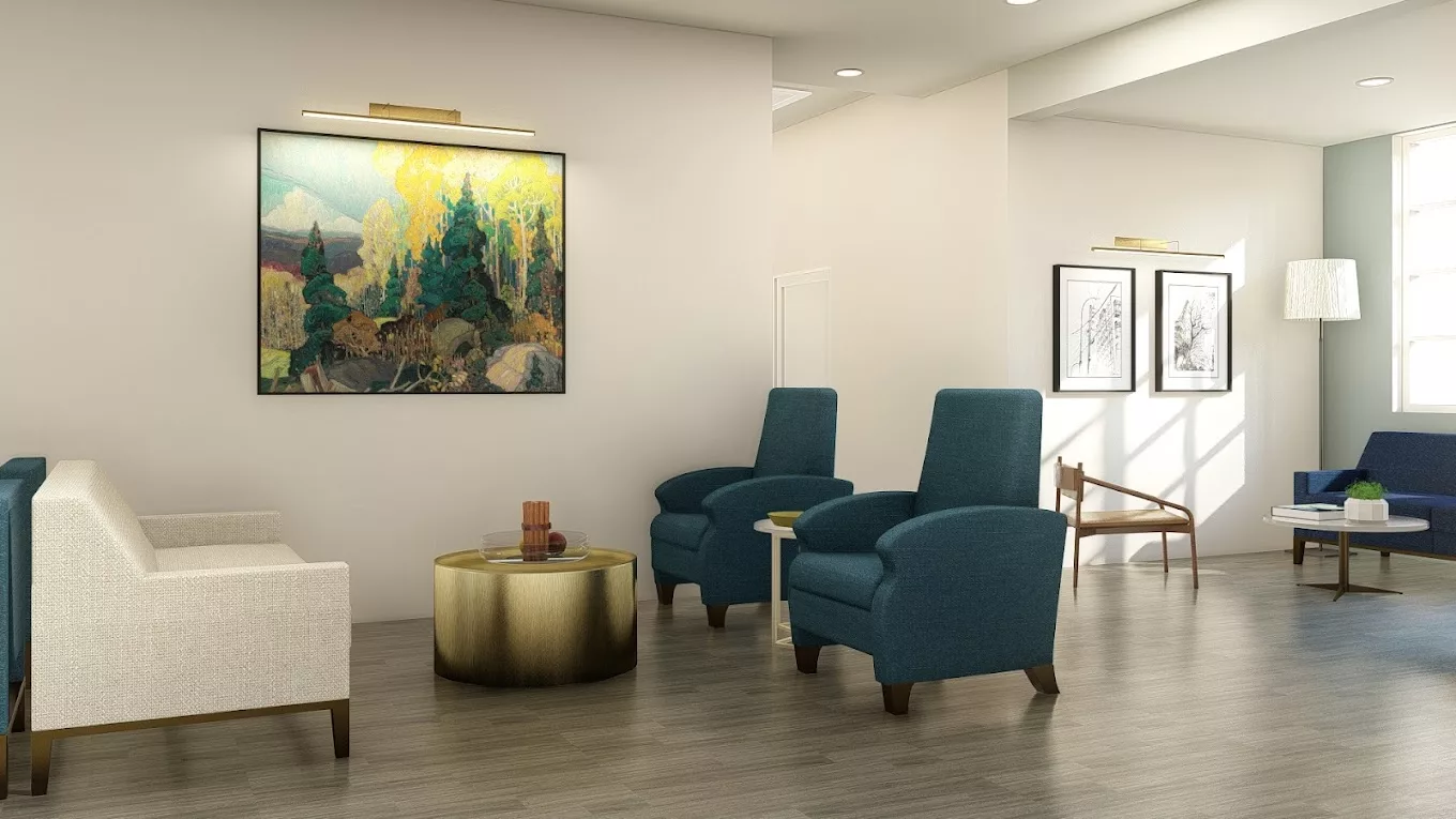 A modern living room with blue chairs, a gold coffee table, and landscape artwork on the wall.