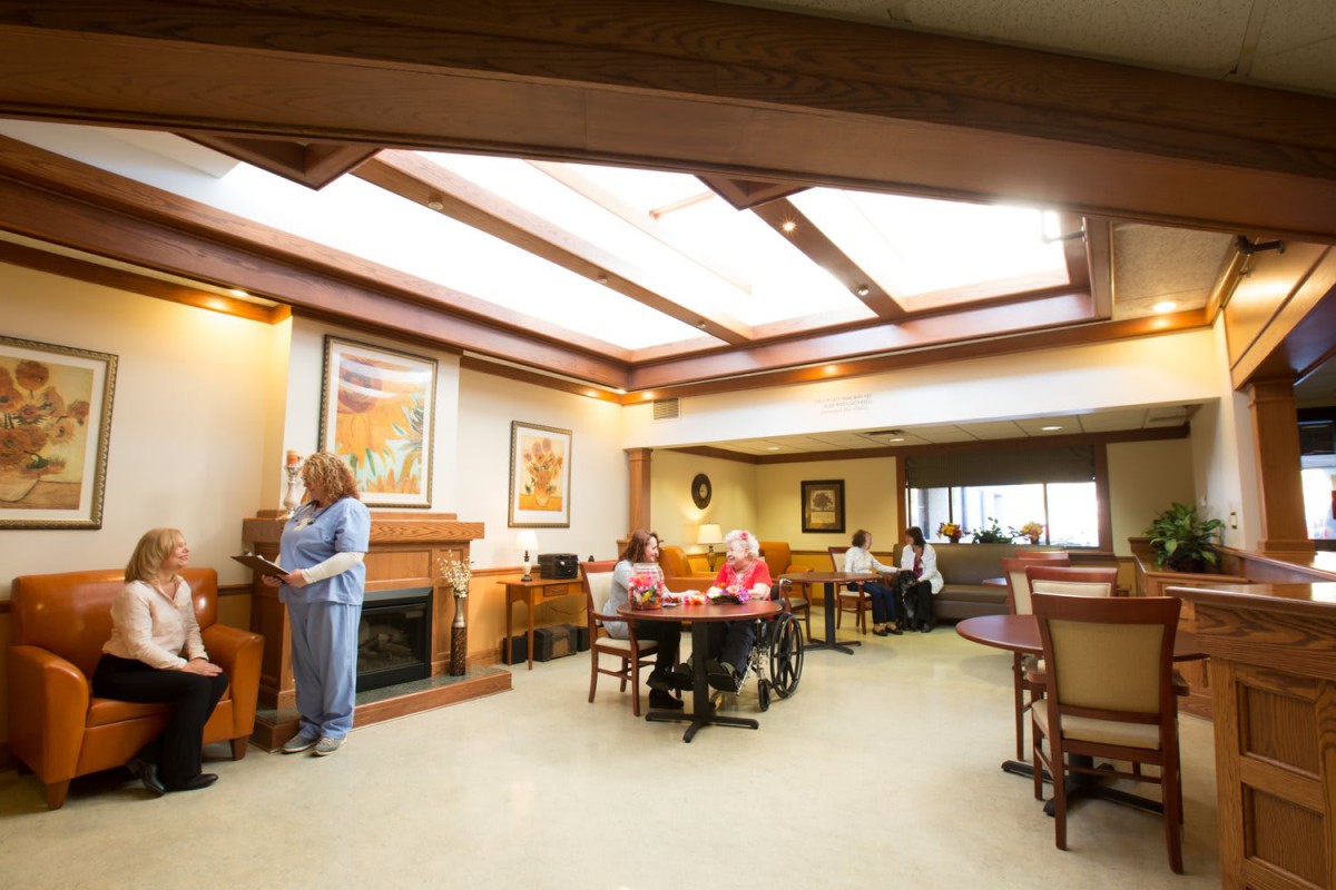 A cozy lounge area with people seated and socializing, featuring comfortable furniture and warm lighting.