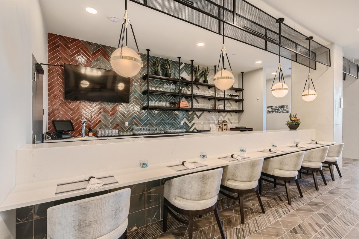 Contemporary restaurant interior with stylish bar seating and modern lighting.