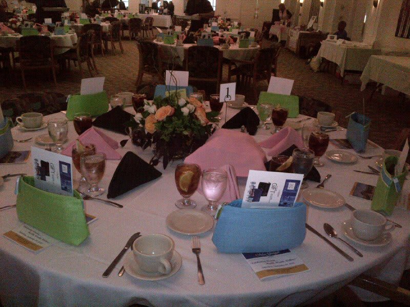 A beautifully arranged table set for a formal event, featuring elegant tableware, colorful napkins, and decorative centerpieces.