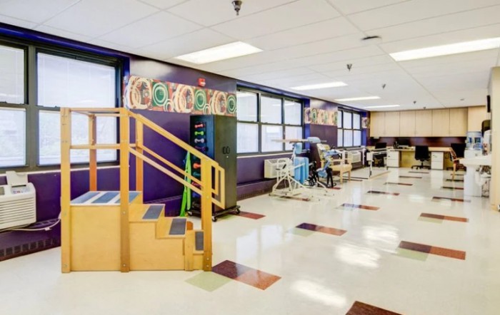 A spacious rehabilitation clinic with therapy equipment and stairs for physical exercises.