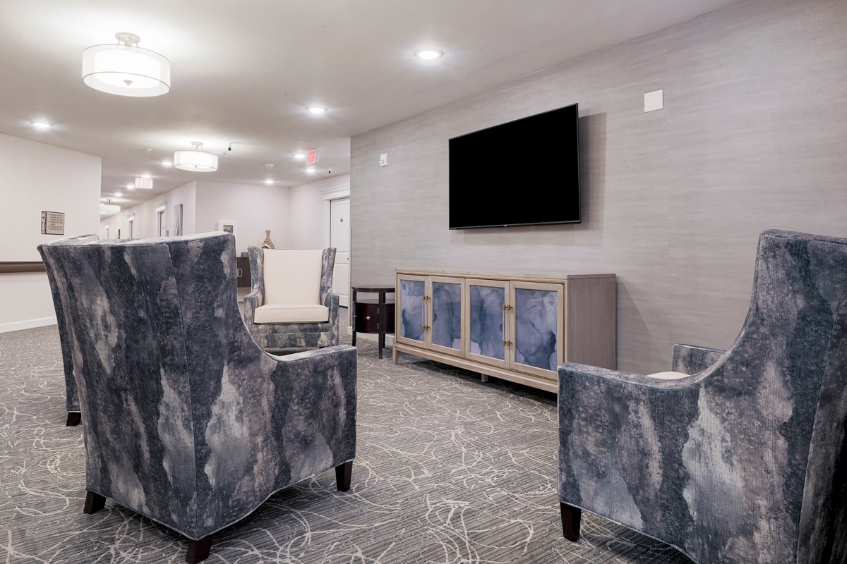 A modern living room with stylish furniture and a wall-mounted television.