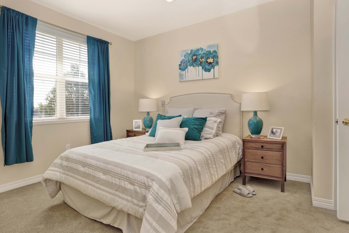 A cozy bedroom with neutral colors and blue accents.