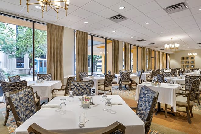 Elegant dining room with neatly arranged tables and large windows.