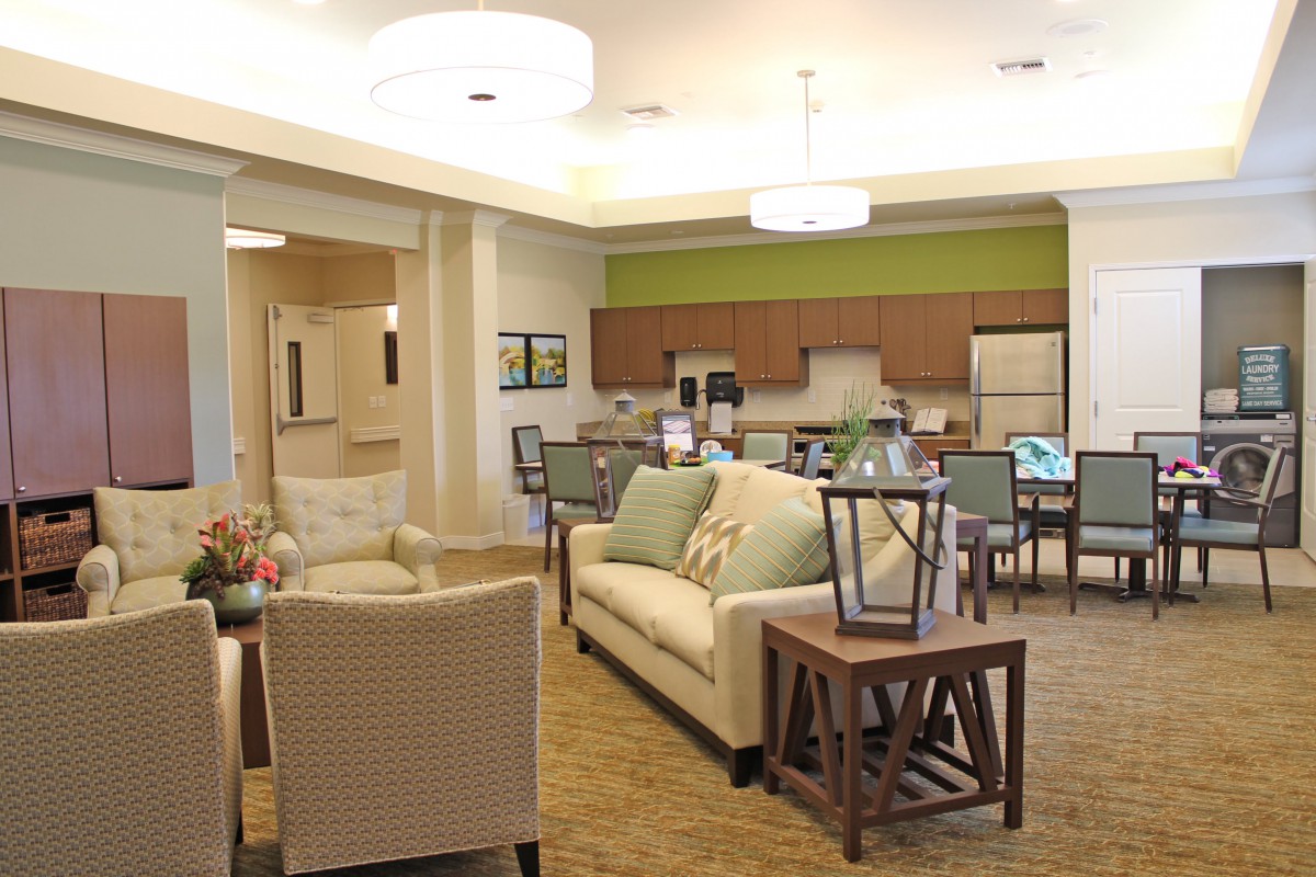 A modern open-concept living and dining area with a kitchen in the background.