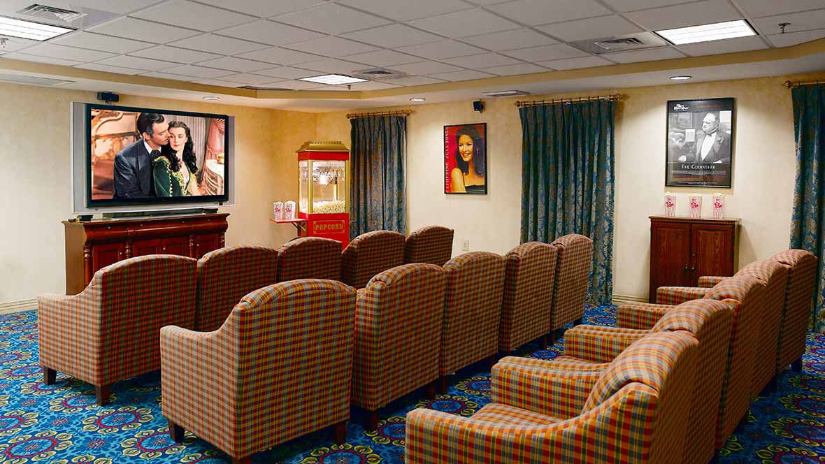 A cozy home theater room with comfortable seating and a popcorn machine.