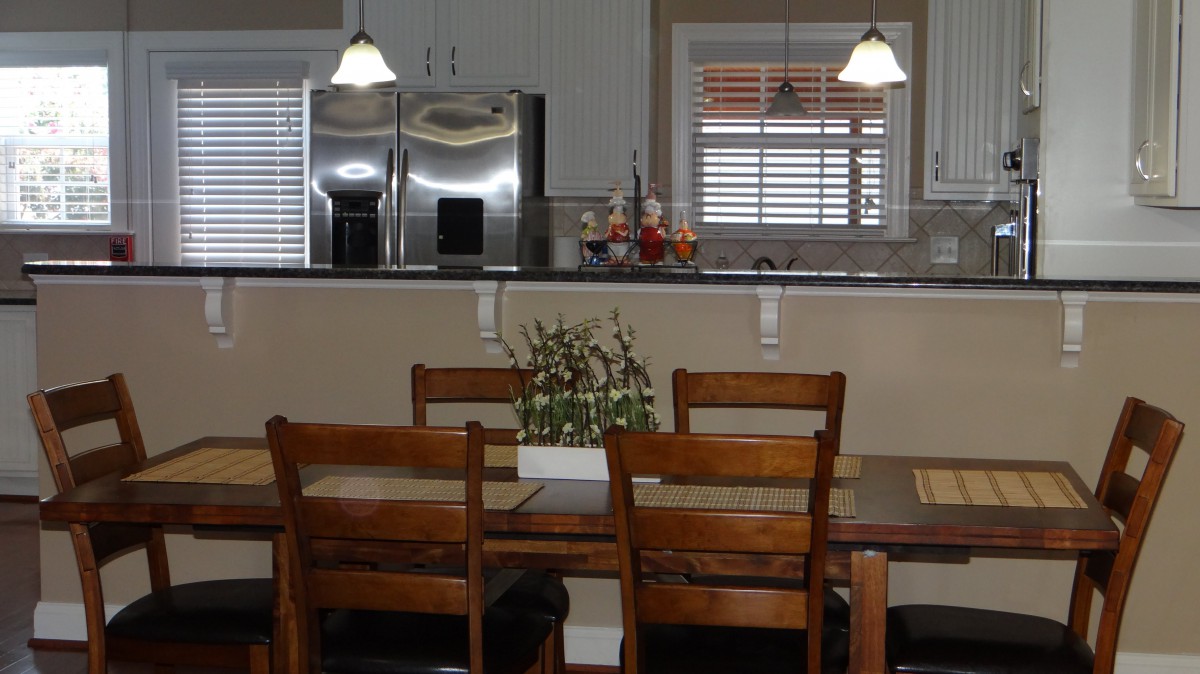 A cozy kitchen and dining area with wooden furniture and modern appliances.
