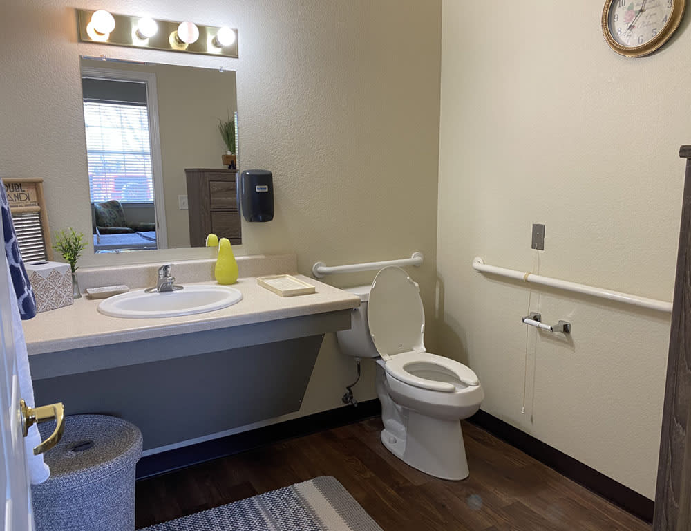 A clean and well-lit bathroom with a sink and toilet setup.