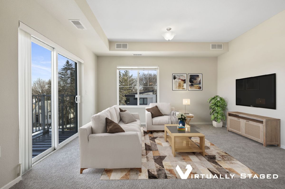 A modern living room with a cozy sofa set, coffee table, and large windows providing ample natural light.