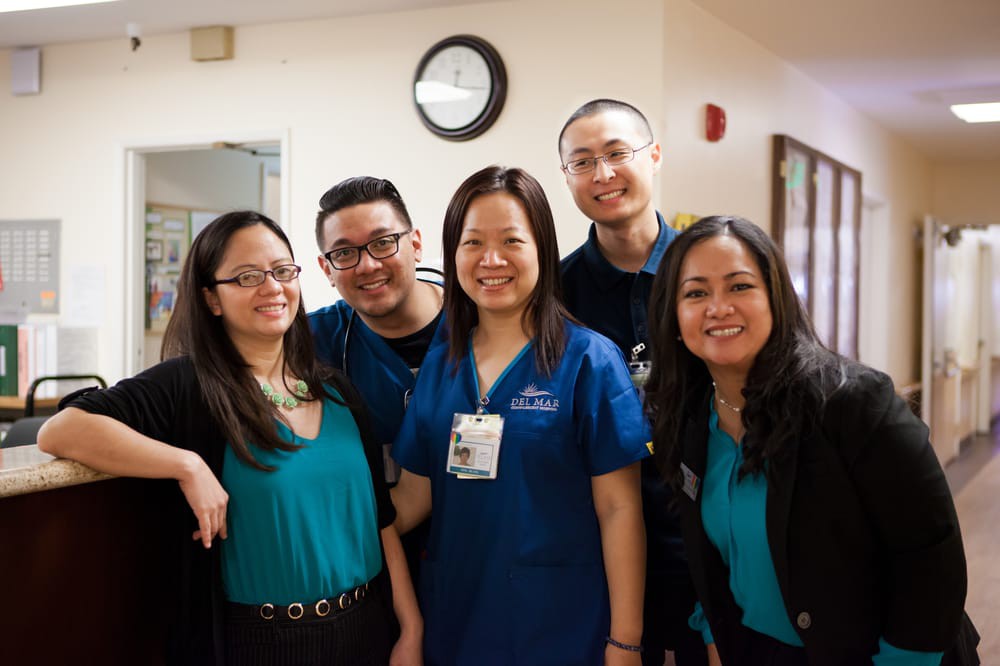A group of smiling medical staff in a hospital setting.