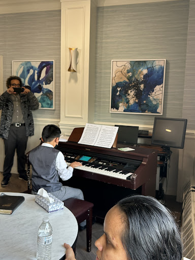A young pianist performs at an event, showcasing their talent in front of an audience.