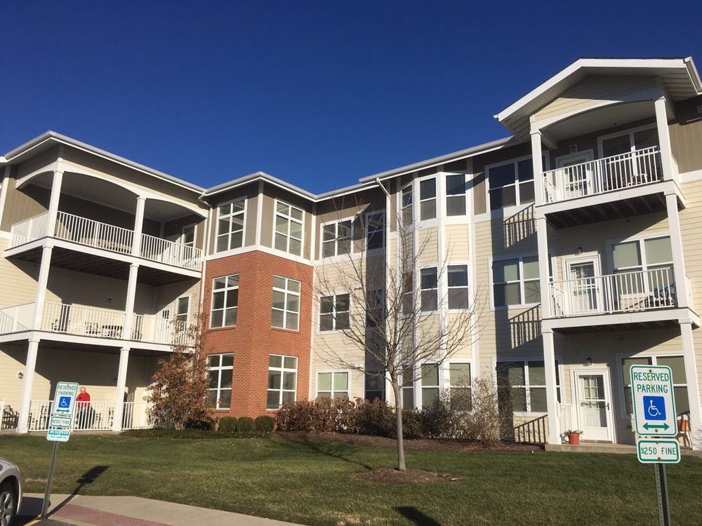 A modern apartment building with a brick facade and multiple balconies under clear blue skies.