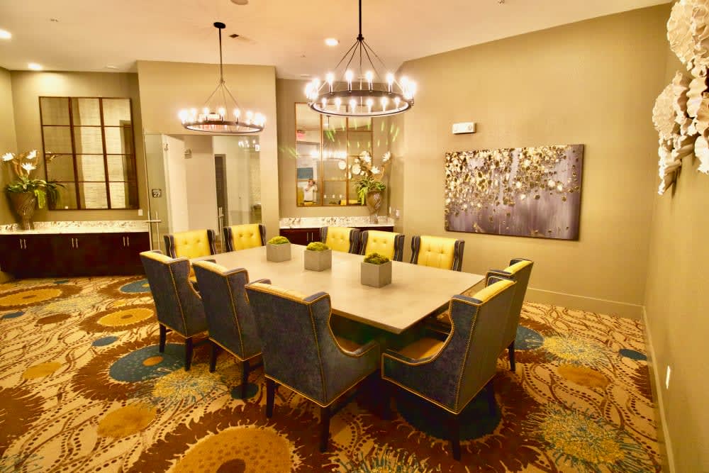 A modern dining room with a chandelier, stylish table, and comfortable seating.