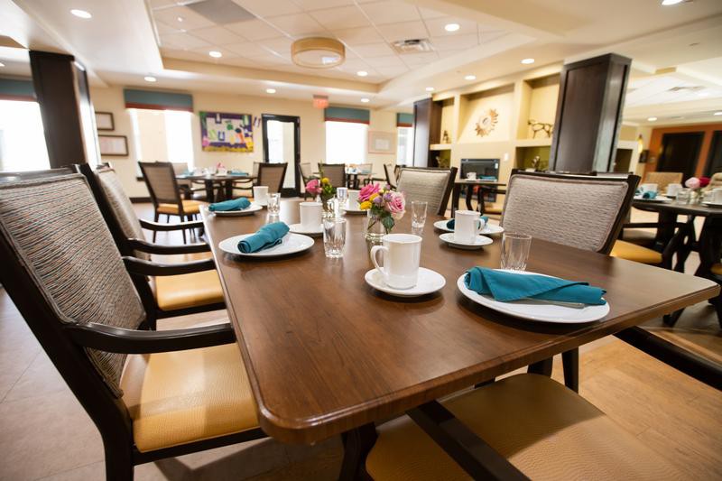 A modern dining room with neatly set tables and comfortable seating.