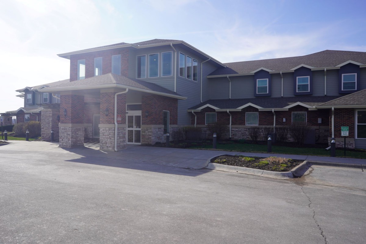A suburban residential building with a driveway and front yard.