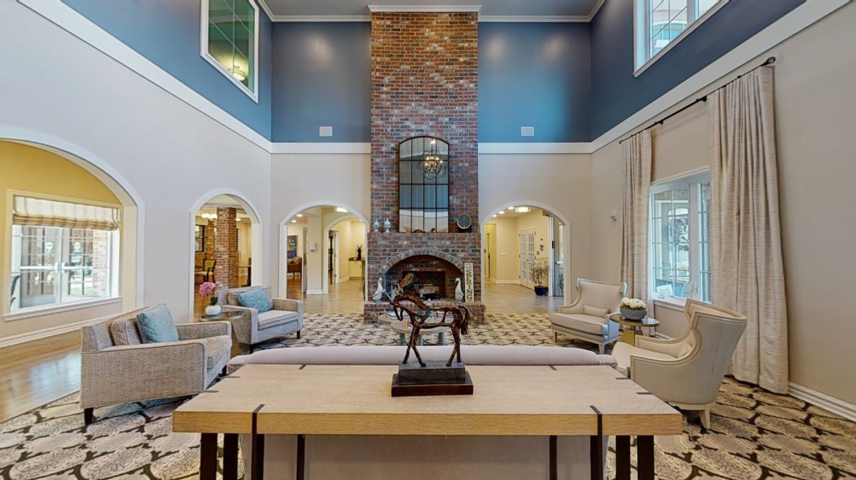 Spacious living room with high ceilings and a central fireplace.