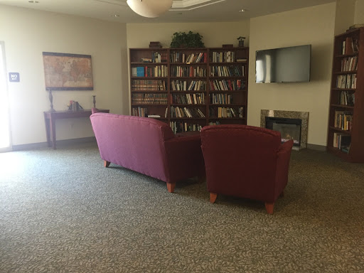 A cozy library corner featuring a bookshelf filled with books and comfortable seating.