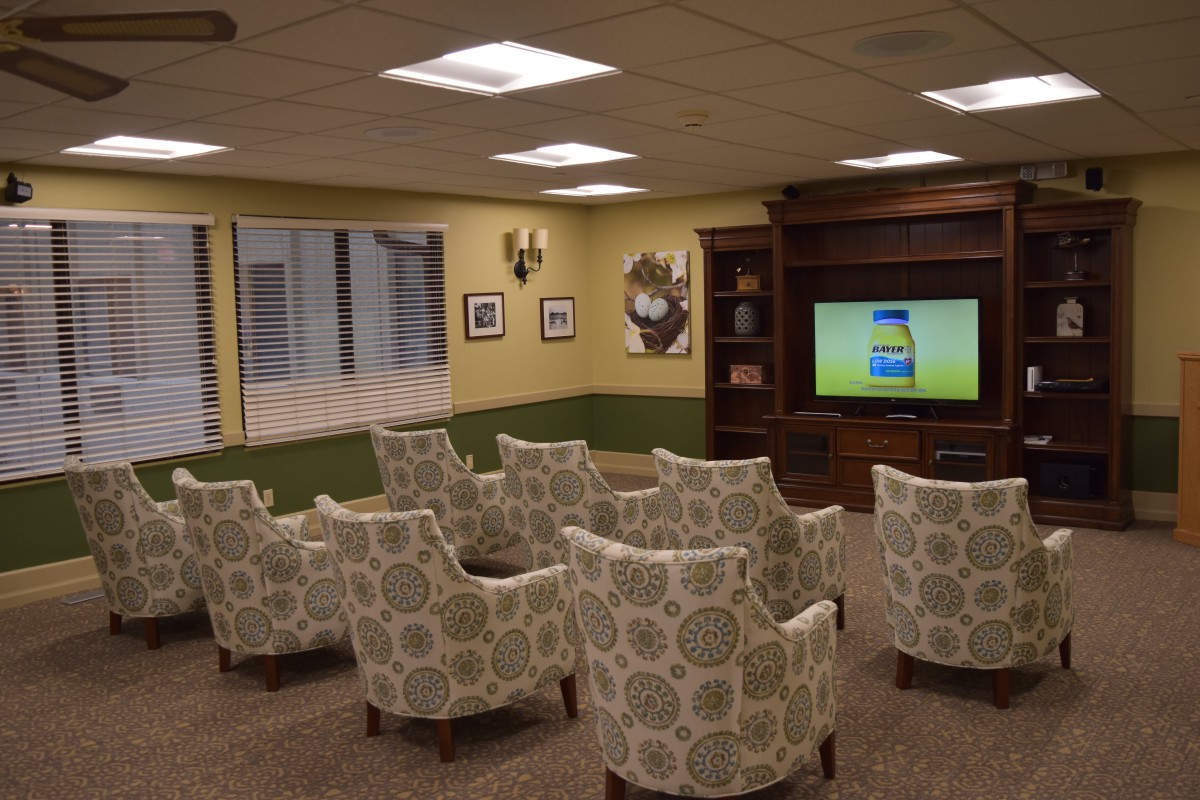 A cozy lounge area with patterned chairs facing a television.