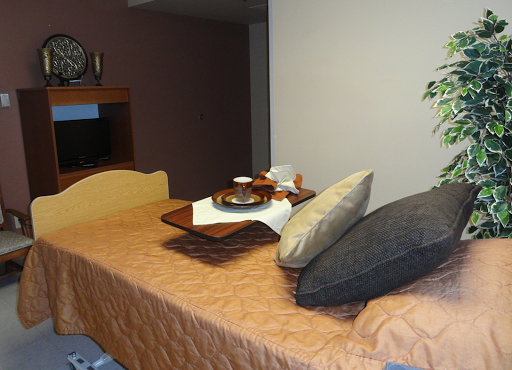 A cozy hotel room featuring a neatly made bed with decorative pillows and a breakfast tray.