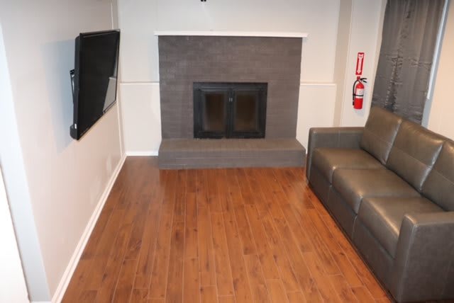 A cozy living room featuring a fireplace, hardwood floors, and a comfortable sofa.