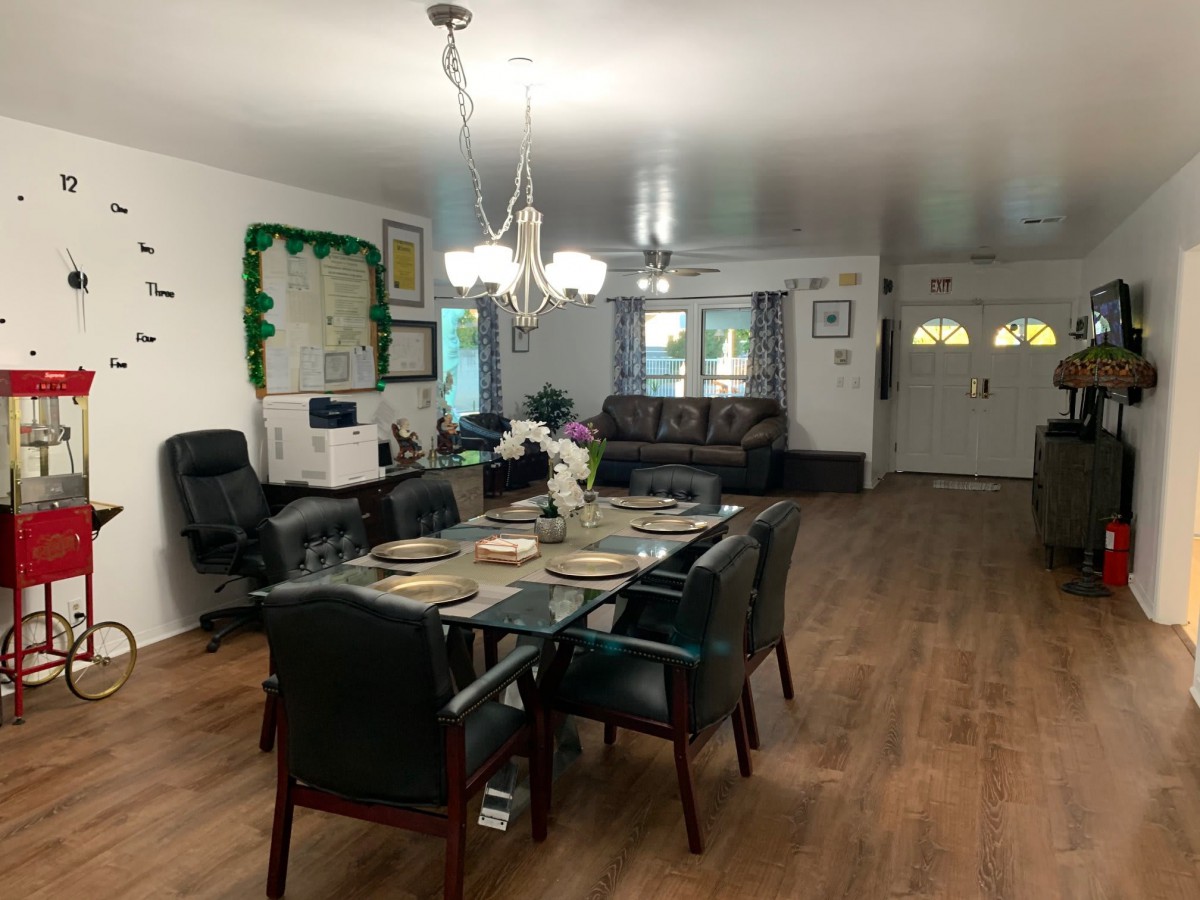 A spacious dining and living area with a well-set table, comfortable seating, and elegant lighting.
