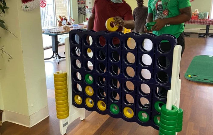 People playing a giant version of Connect Four indoors.
