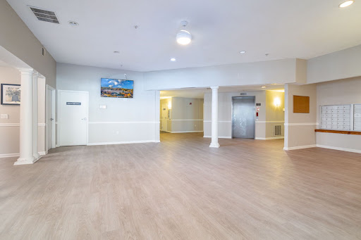 A spacious and well-lit reception area with modern flooring and an elevator.