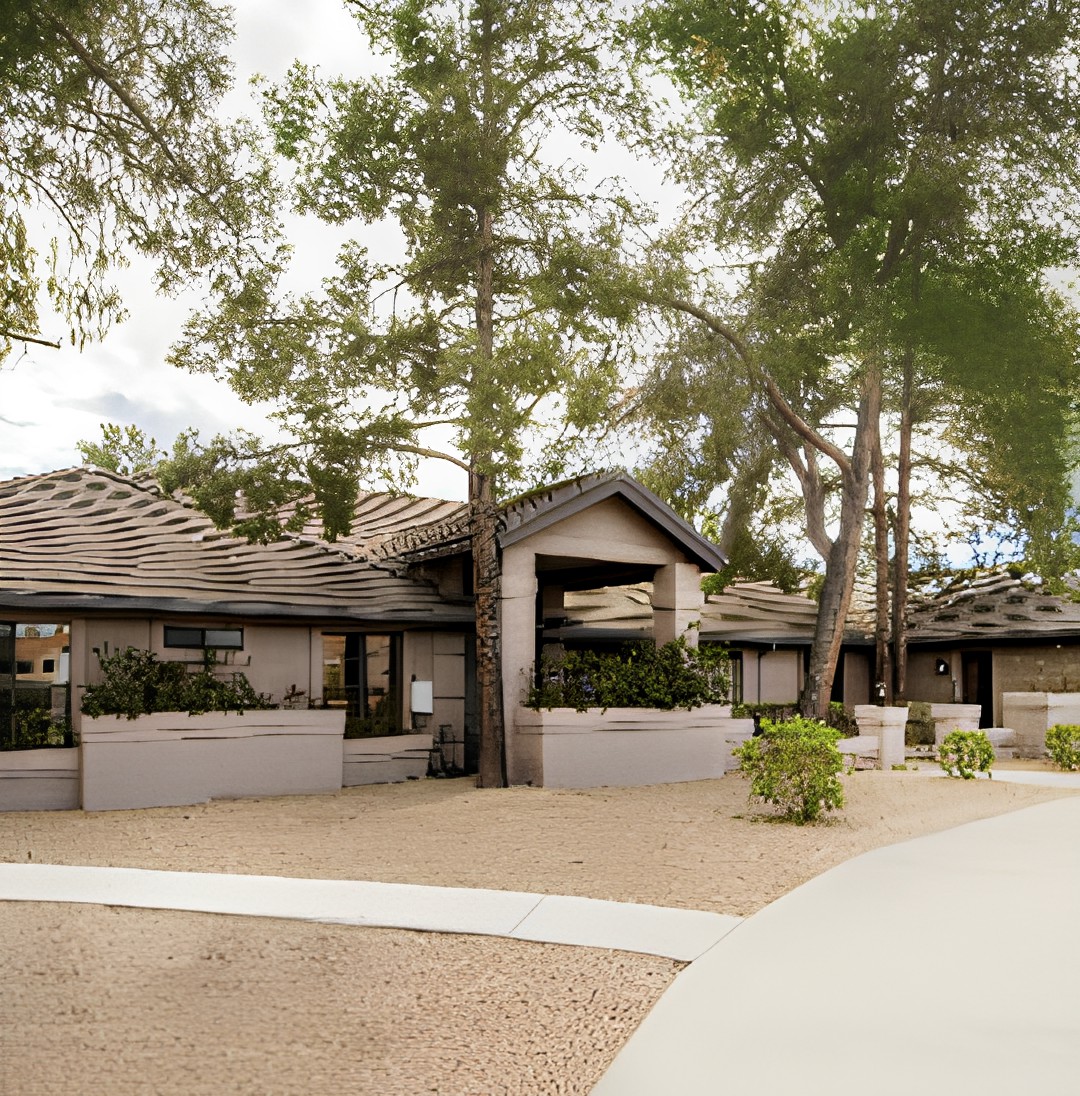 A modern residential home surrounded by trees and neatly landscaped grounds.