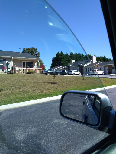 A view of a suburban neighborhood with houses lined up under a clear blue sky.