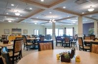 A spacious and well-lit dining area with multiple tables and chairs arranged neatly.