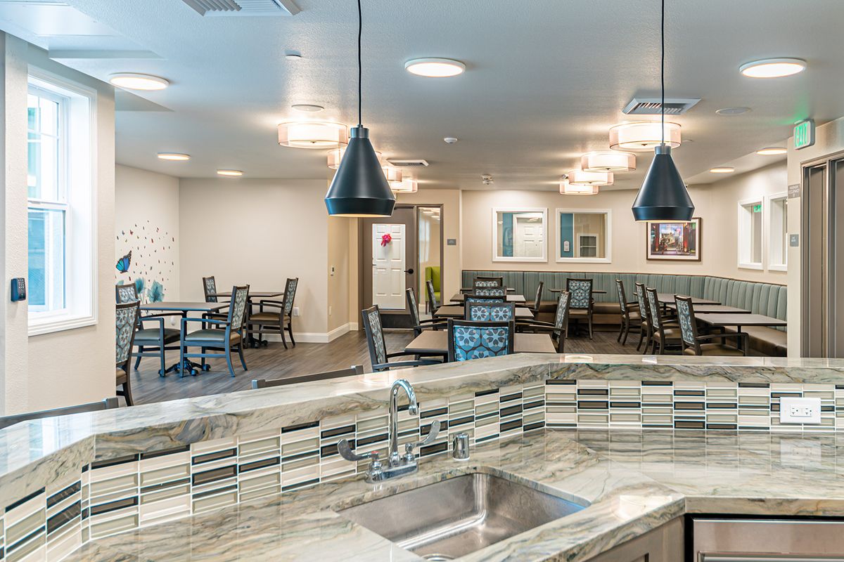 A modern kitchen and dining area with pendant lighting and ample seating.